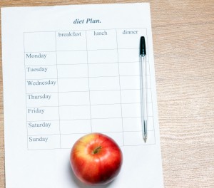 diet Plan. diet plan, pencil and apple lying on a wooden surface